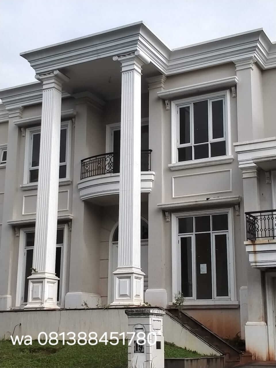 Rumah dengan tiang beralur, lis atap, dan bingkai jendela profil beton